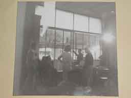 <p>This is a really amazing photo.  It was shot from inside the bank while scene direction appears to be taking place.  The three actors in the scene are there - Eddie Holmes (seated), along with DeAnn Mears and Susan Oliver.</p><p>The man in the center, pointing out the window appears to be giving directions. Can anyone identify him?